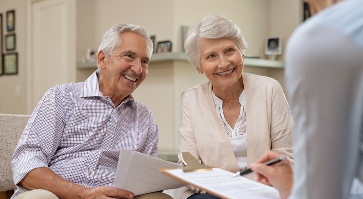 A senior couple reviewing the terms of their 401(k) with a financial advisor.