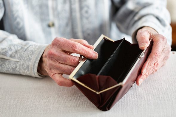 Elderly woman opening an empty purse
