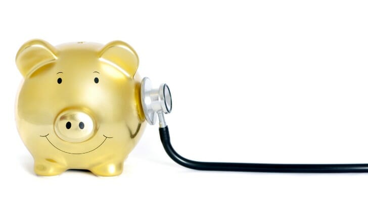 https://smartasset.com/wp-content/uploads/sites/2/2018/10/yellow-piggy-bank-with-stethoscope-on-his-side-picture-id182864067.jpg