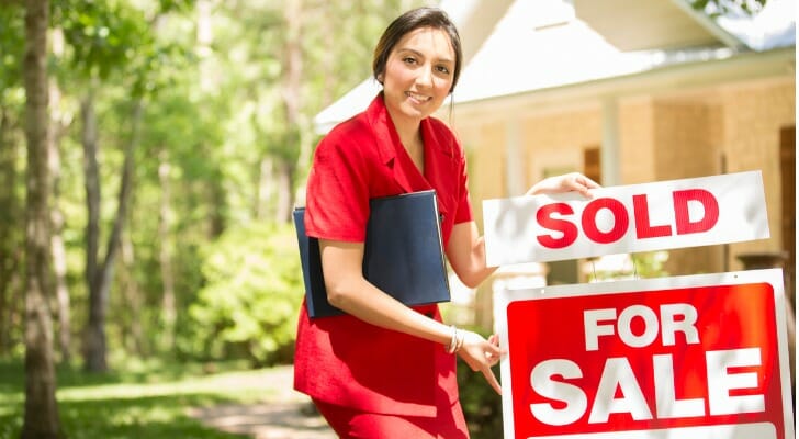Real estate agent outside a newly sold property