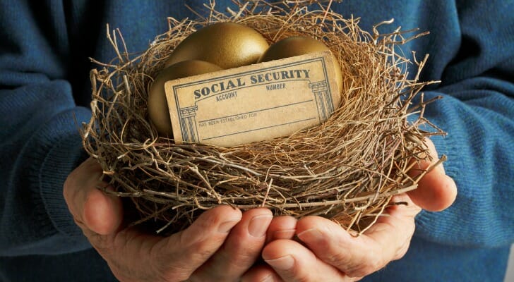 Man holding a bird's nest with a Social Security card and gold egg in it