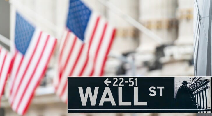 American flags with Wall Street sign in the foreground