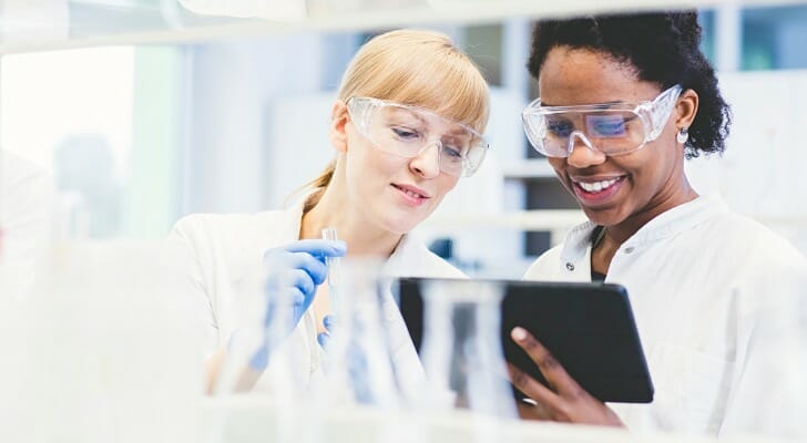 Image shows two scientists reviewing data in a lab. SmartAsset analyzed data across gender and race lines to find the best cities for diversity in STEM.