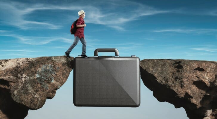 Student crossing from one precipice to another by walking on a briefcase