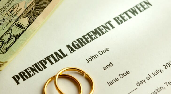 A prenuptial agreement with a set of wedding rings on top