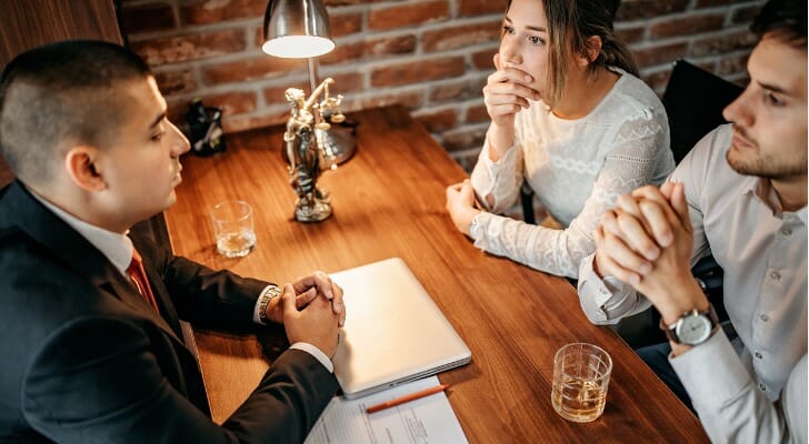 Engaged couple meets with lawyer about a prenuptial agreement