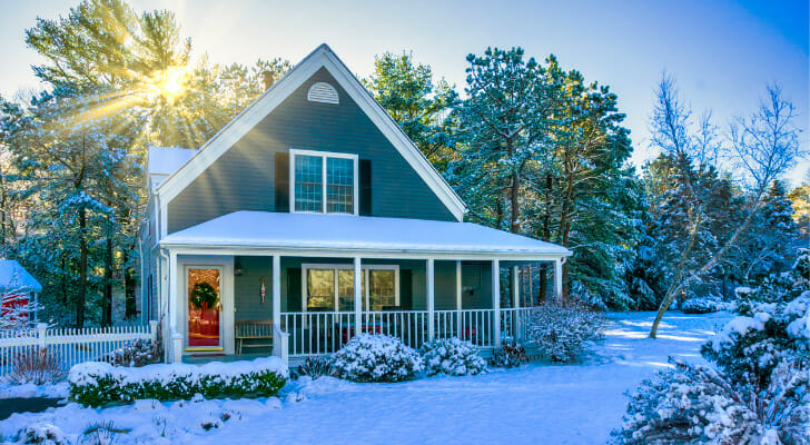 Image shows a suburban home with a snow-covered lawn and trees surrounding it. In this study, SmartAsset found the salary needed to afford home payments in the 15 largest U.S. cities.