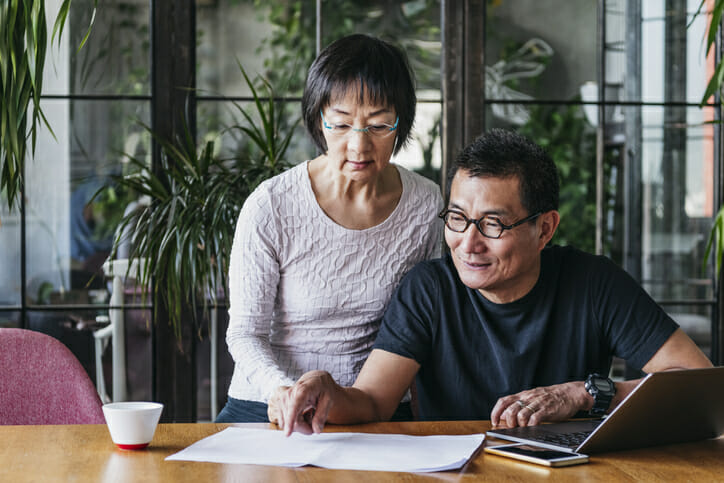 A senior couple reviewing requirements to complete a rollover from an IRA to a 401(k).