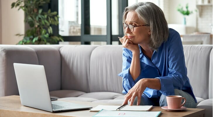 Senior woman checks her tax-deferred investment account