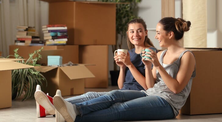 Roommates take a break from unpacking boxes. SmartAsset set out to find out how much you can save by living with a roommate in 50 of the largest U.S. cities.