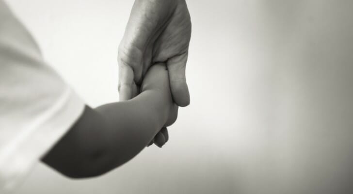 Adult holding the hand of a child