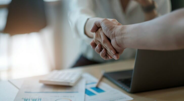Husband and wife shake hands on their agreement to use a joint brokerage account
