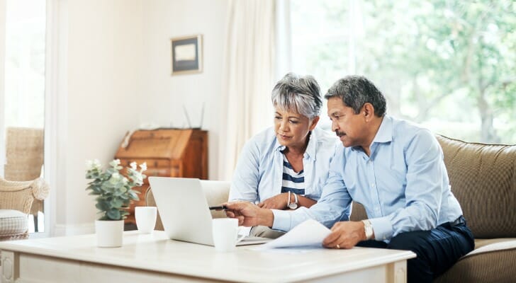 A couple looks over their Social Security benefits on a laptop. 