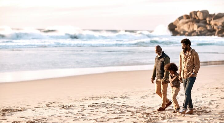 This image shows a grandfather walking on the beach with his grandson. New FAFSA and 529 rules impact grandparent college savings accounts.
