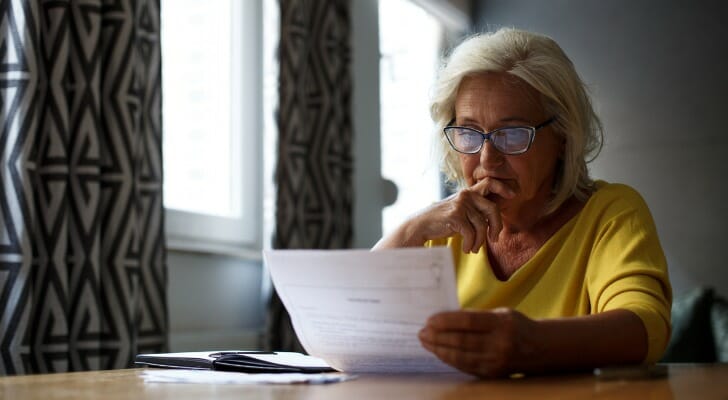 Image shows a woman reviewing her finances. Fidelity Investments plans to launch a new product next year that will allow individuals to shift a portion of their employer-sponsored retirement plan into an annuity.