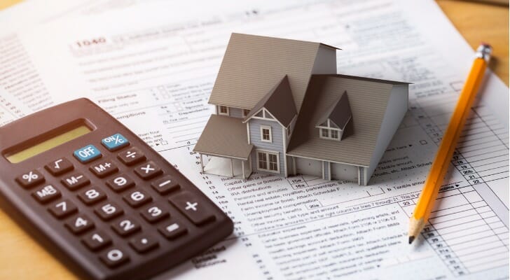 Tax documents, calculator and model of a house