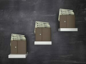 Three wallets with hundred dollar bills sit on shelves of different heights.