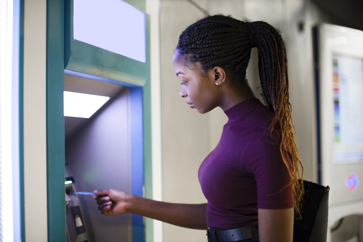 Young woman getting money from an ATM.