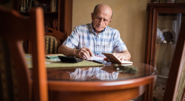 how much does Medicare cost? Elderly man calculating healthcare costs.