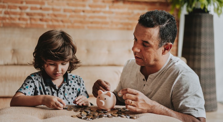 A man teaching his son about gold IRA investing and saving for retirement in a 401(k)