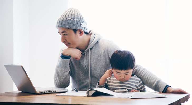 A father sits with his son as he looks over his options for student loan forbearance.