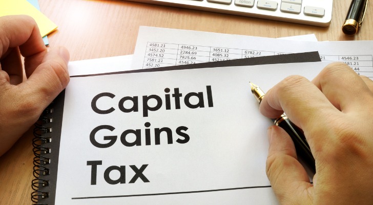 Man reviews documents related to his capital gains tax obligations.