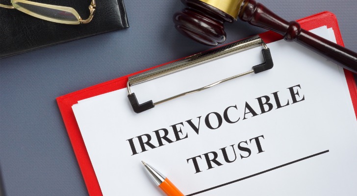 A pen and a gavel rest on top of irrevocable trust documentation. 