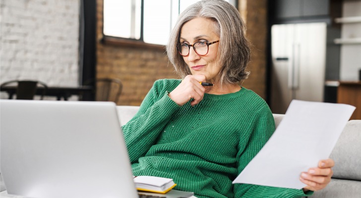A woman reviews her retirement account before requesting an indirect rollover.