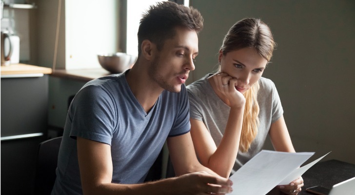 A couple looks over their assets and liabilities to calculate their net worth.