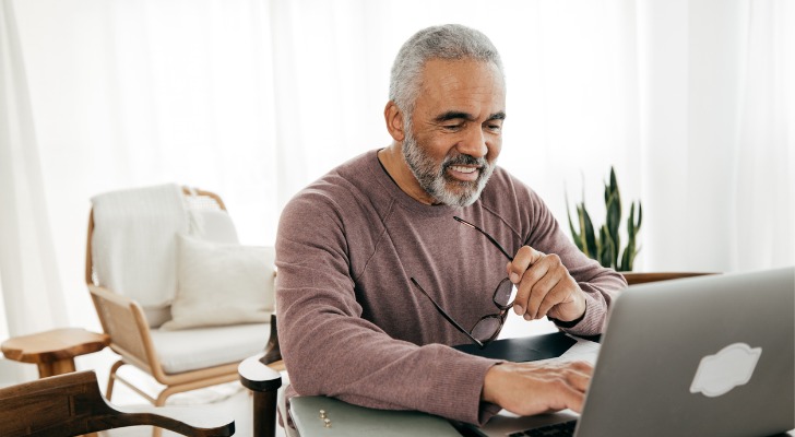A man looks over his retirement account and considers investing in ETFs over mutual funds. 