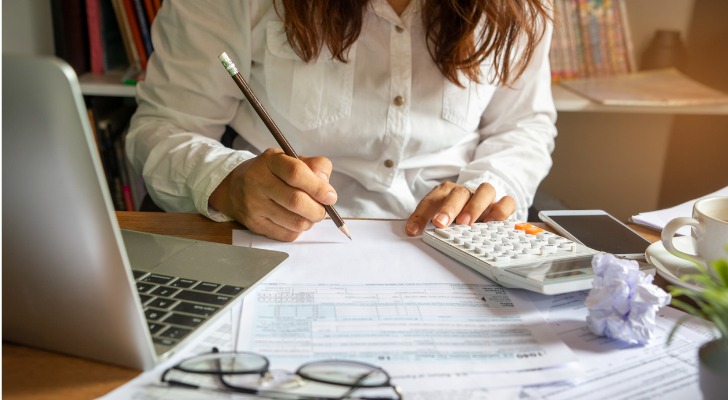 A taxpayer reviews her income and tallies up her deductions and tax credits.