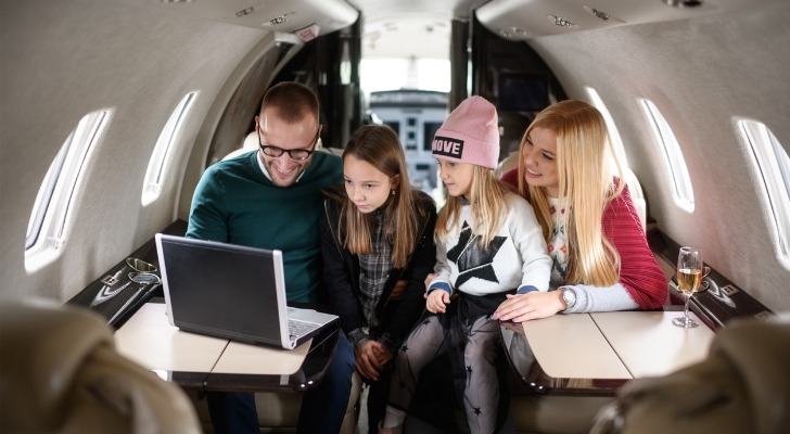 ultra high net worth family on a private jet looking at family office options