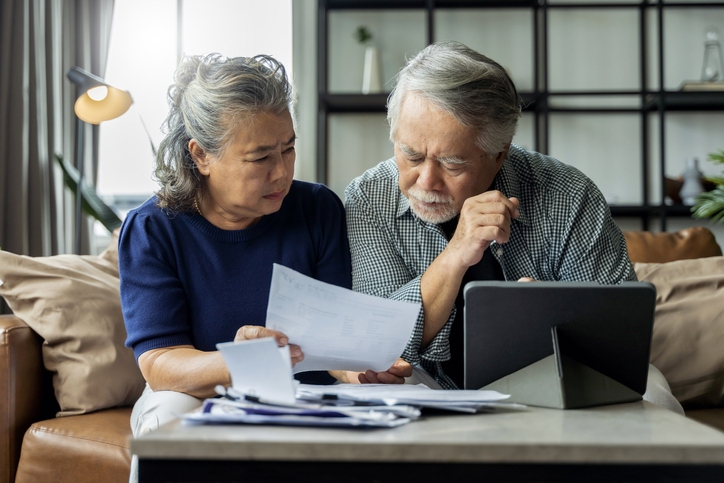 A retired couple looks over their long-term care insurance premiums.
