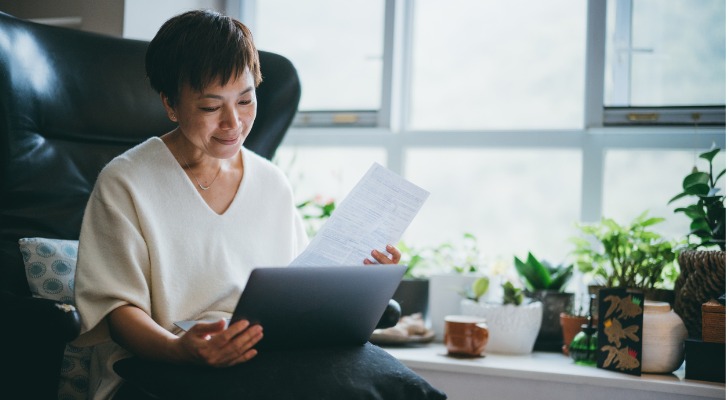 A woman looks over her Roth IRA as she thinks about whether she can retire at age 62.