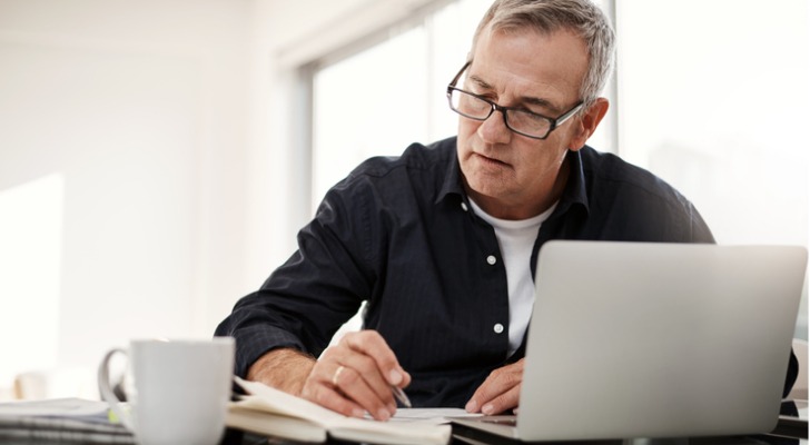 A man looks over his financial plan to determine whether he can retire at age 65.