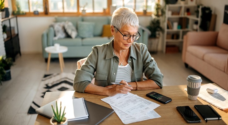 A woman reviewing types of fees associated with a Roth IRA.