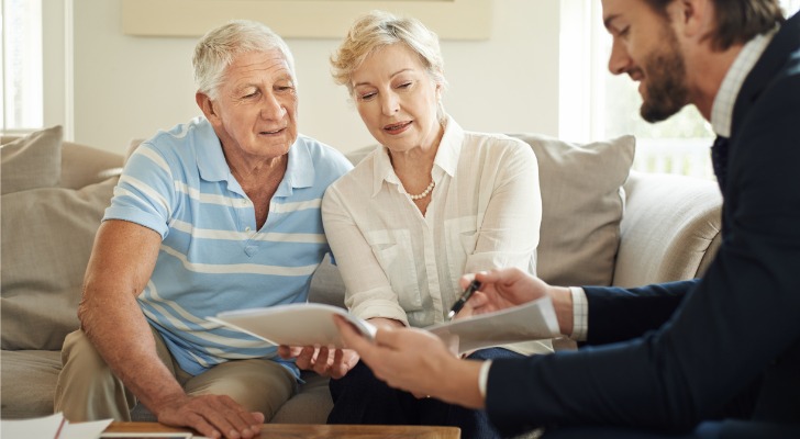 A financial advisor explaining the differences between a living trust and a will to clients.