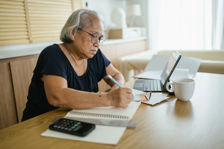 A senior making a checklist to decide the pros and cons of unretiring. 