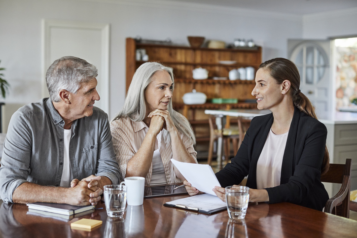 A senior couple meeting with their financial advisor to review an annuity policy.