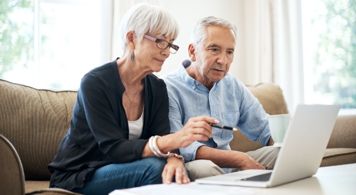 A senior couple reviewing the fees they pay with a Roth IRA.