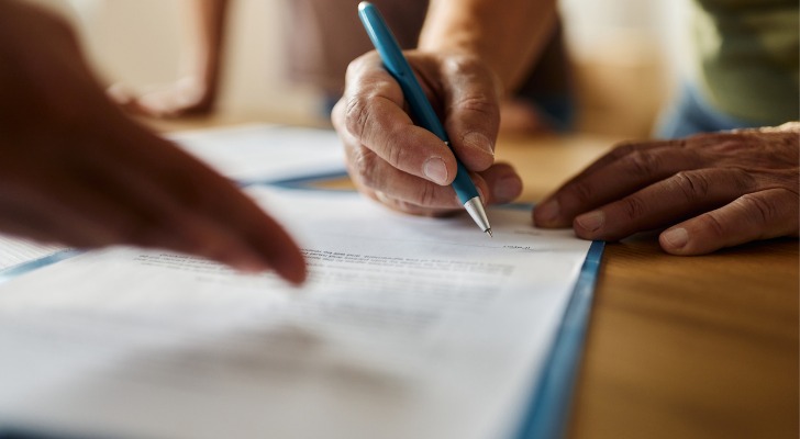 A person signs mortgage documents. 