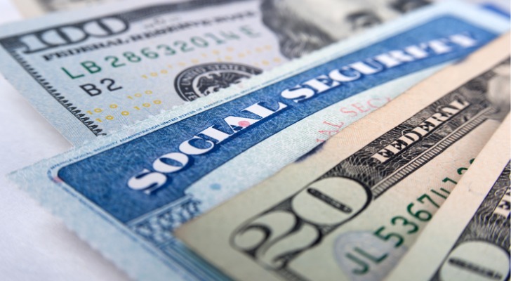 A Social Security card is sandwiched between $100 and $20 bills.