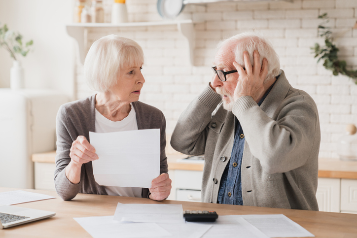 A senior couple reviewing tax consequences for missing a required minimum distribution.