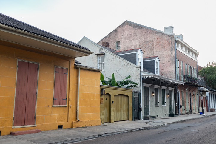 A row of colorful and beautiful old homes and buildings along an empty street in the French Quarter of New Orleans