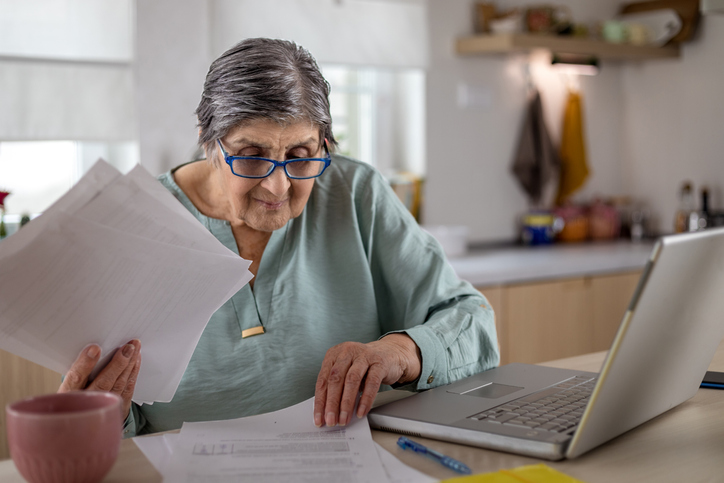 A senior woman estimating how much she will need to withdraw from her retirement accounts.