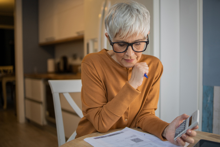 A senior woman calculating probate expenses after a loved one passed.