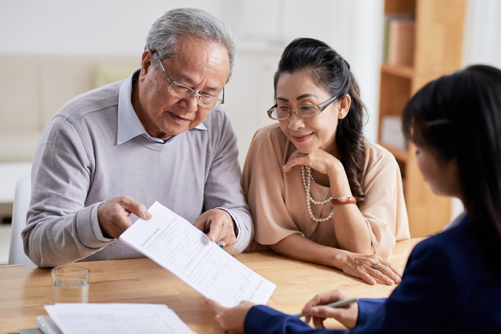 A senior couple creating an estate plan with a financial advisor to avoid probate with their family. 