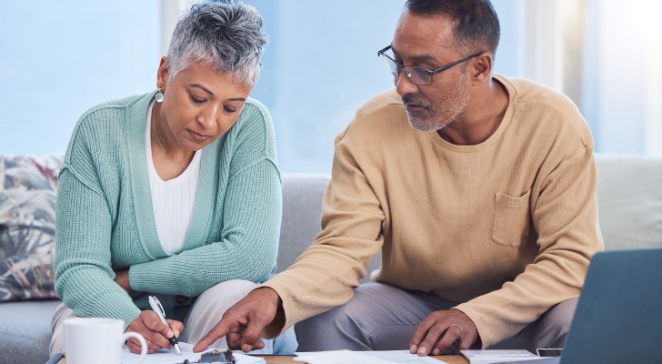 A couple signs estate planning documents to help them avoid probate in Michigan.