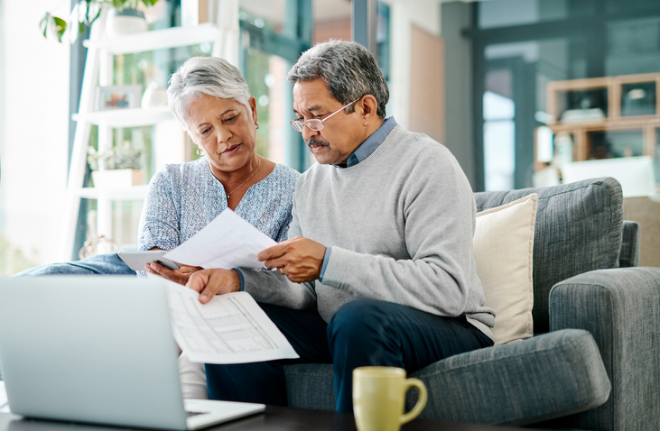A senior couple reviews documents for their retirement and estate plans.