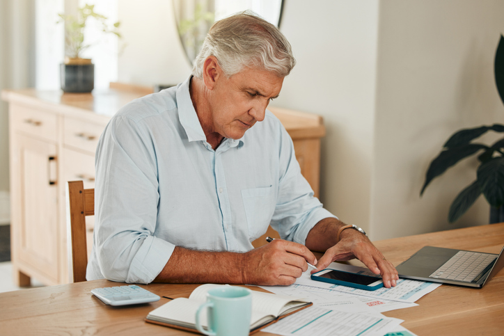 A 60-year-old man looks over at his financial plan for retirement. 